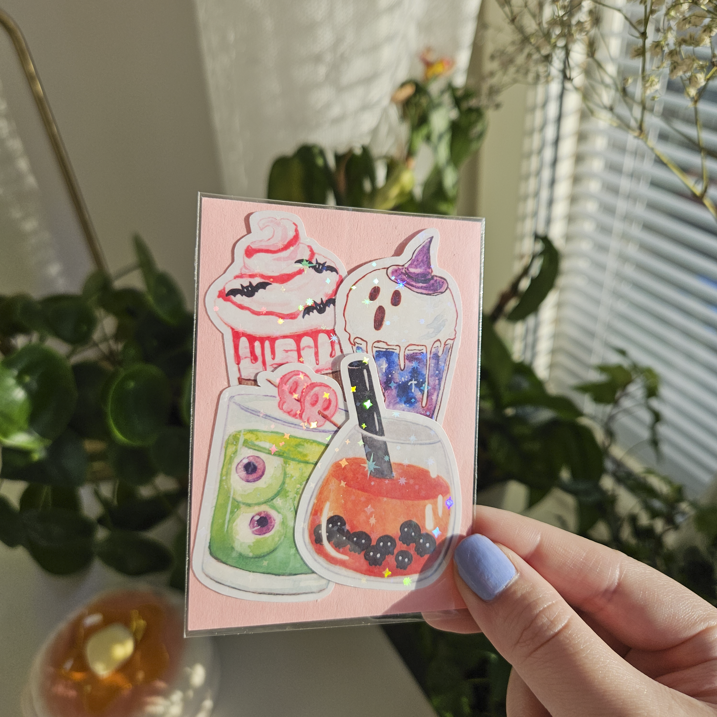 One pink sticker pack with 4 stickers inside. Halloween themed drinks. Sparkly picture.